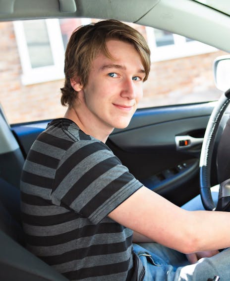Jongen zit achter het stuur in de auto